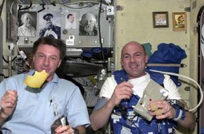 European Space Agency astronaut Andre Kuipers (R) and his NASA colleague Michael Foale eat Dutch cheese for breakfast on the International Space Station.