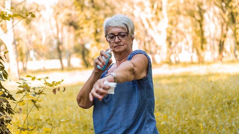 woman putting on bug spray