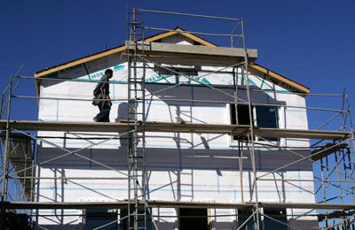 Workers build structure at construction site.