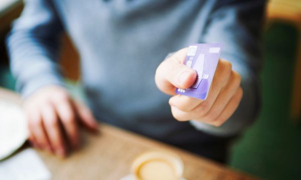 Man holding credit card in cafe