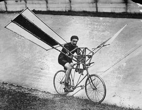 A man rides a bicycle with wings attached to its frame.