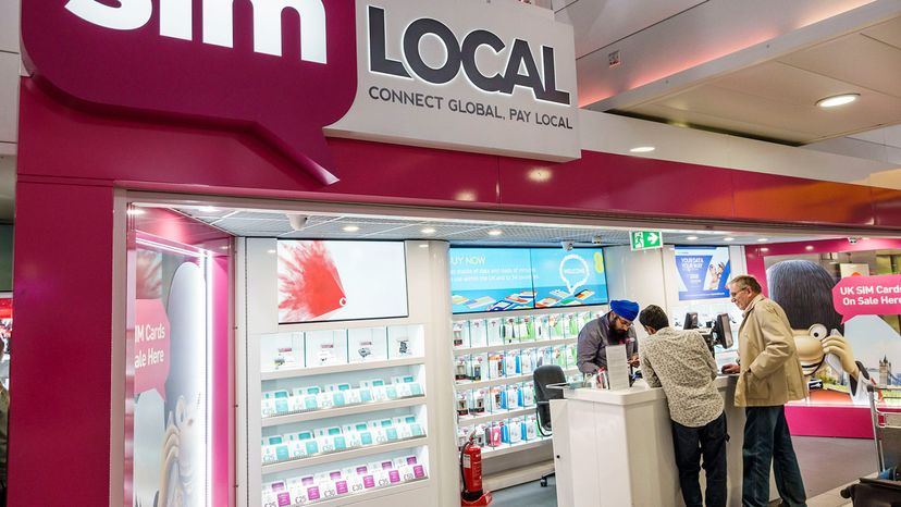 Two men shopping at a SIM Local prepaid wireless store.