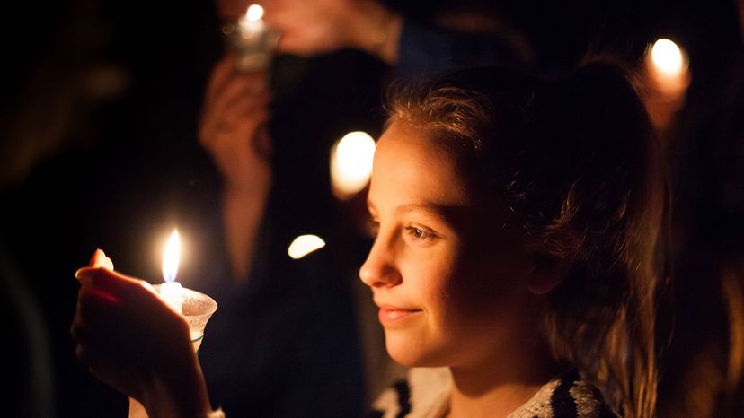 girl lights a candle during the Burns Night 