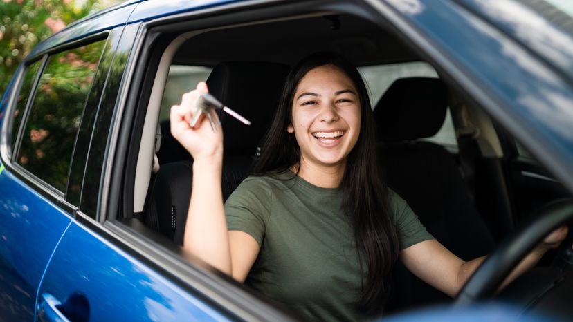 Woman with keys in hand proud of getting a new car.