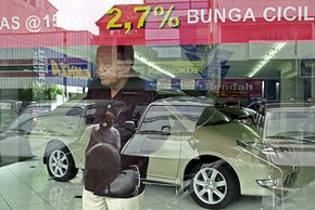 A car dealer in Jakarta, Indonesia, surveys the customers on his lot outside.