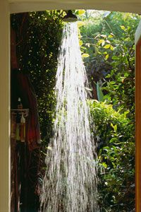 Water falling from a waterfall shower head on an outdoor shower.&nbsp;