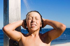 A young boy using an outdoor shower.&nbsp;