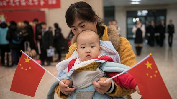Baby holds flag during Chunyun travel rush