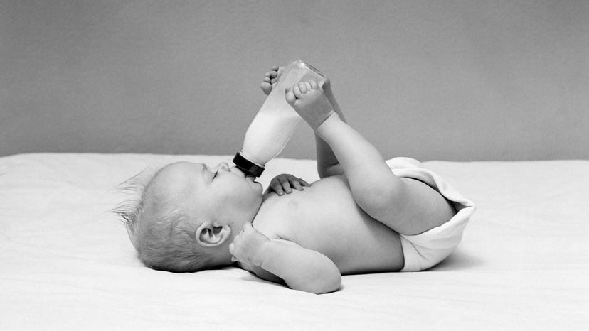 baby feeding itself with bottle