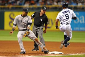 Infielder Robinson Cano, No. 24, of the New York Yankees covers first base as outfielder Desmond Jennings, No. 8, of the Tampa Bay Rays runs out a bunt. See more sports pictures.