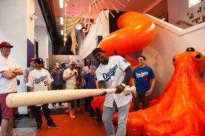 这是一个很大的一个!Yasiel Puig,洛杉矶道奇队的66号,与一个超大的蝙蝠在访问美国职棒大联盟球迷洞穴在纽约市。”width=