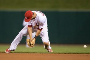 Daniel Descalso of the St. Louis Cardinals makes an error on a ground ball in the eighth inning in a game against the Cincinnati Reds. See more sports pictures.
