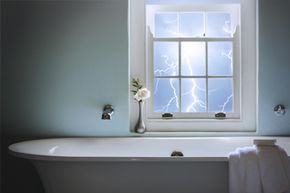 Bathtub with lightning in the background window