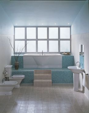Tiles in warm and cool colors form an energetic back- ground for the all-white fixtures and walls in this bath.