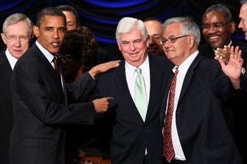 President Barack Obama congratulates Senators Christopher Dodd and Barney Frank after signing the Wall Street reform bill they co-wrote into law on July 21, 2010.  