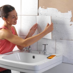 woman tiling above bathroom sink