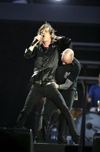 A roadie adjusts Rollling Stone's Mick Jagger's microphone during a recent concert.