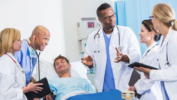 Doctor caring for patient in hospital with stethoscope.