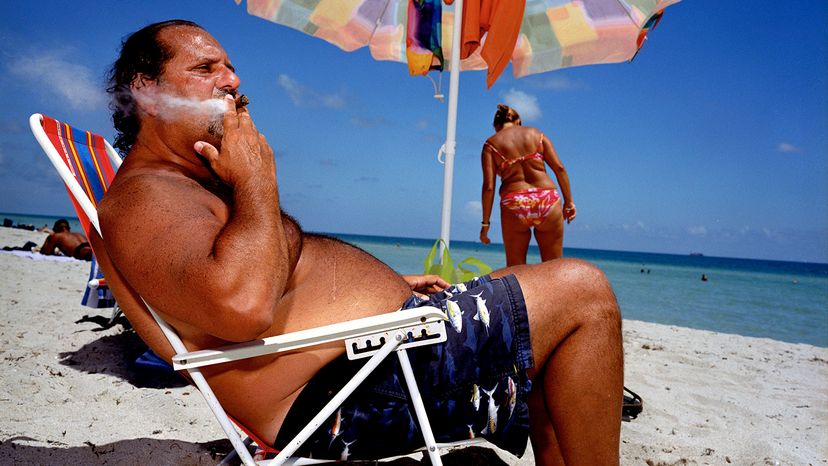 man smoking cigar on beach