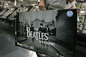 A man walks to a cash register to purchase The Beatles: Rock Band video game in a London store on Sept. 9, 2009.