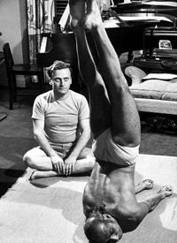 Violinist Yehudi Menuhin observing as Yogi Vithaldas practices yoga.
