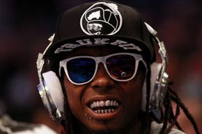 嘻哈歌手Lil' Wayne在2012年NBA全明星赛上戴着Dr. Dre设计的镶钻Beats耳机”border=