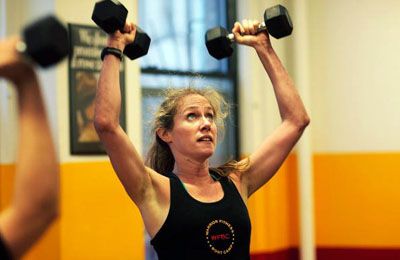 A woman lifts dumbbells during a Warrior Fitness Boot Camp class in New York City