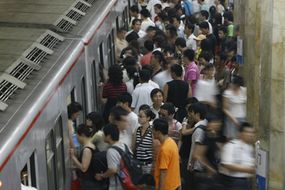 繁忙的北京地铁帮助奥运游客会在城里。”border=