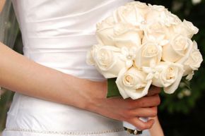 bride holding bouquet of white roses