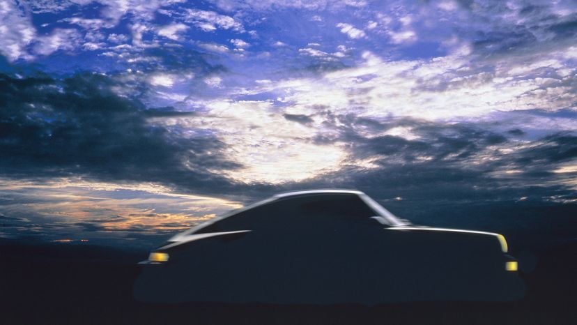 A silhouette of Porshe 911 car in a cloudy sky