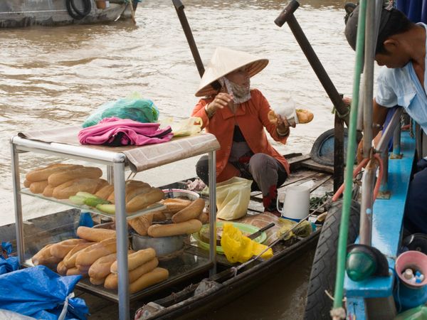 Men selling food outdoors at market vendor.