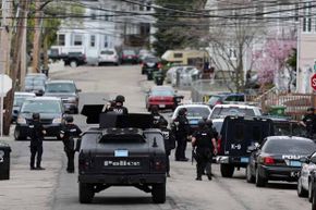 S.W.A.T. teams conduct a house-to-house search during the manhunt for a suspect in the terrorist bombing of the 117th Boston Marathon. See more police pictures.