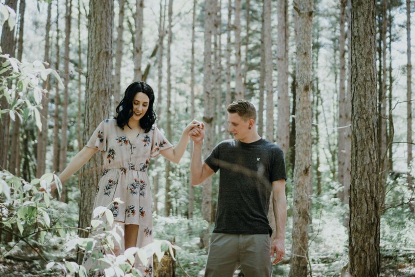 Dating couple walking through the woods holding hands