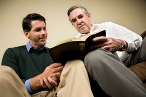 Two men reading together. 