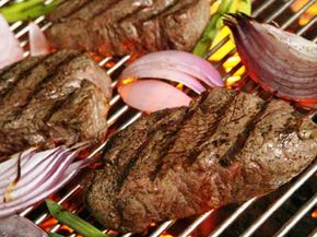 fillet mignon on the grill with grilled oinons