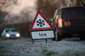 A warning triangle alerts drivers to an icy road in Knutsford, England.