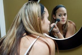 woman applying makeup, woman looking in mirror, makeup