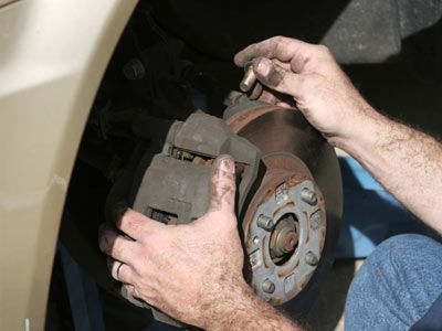 Close-up of mechanic working on auto brakes.