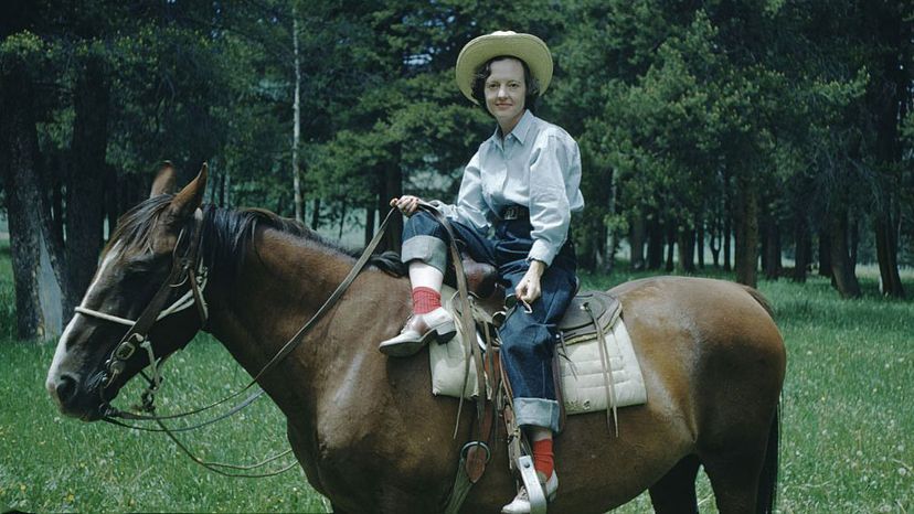 女人在牛仔帽,牛仔裤”border=