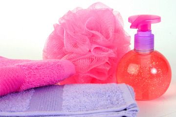 Body Puff, Shower Gel & Towels in pink and lilac hues. Shot on a white ground with deep depth of field for crisp edges.