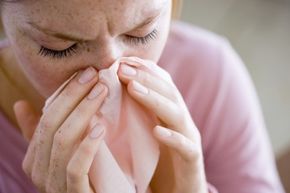 A woman blows her nose.