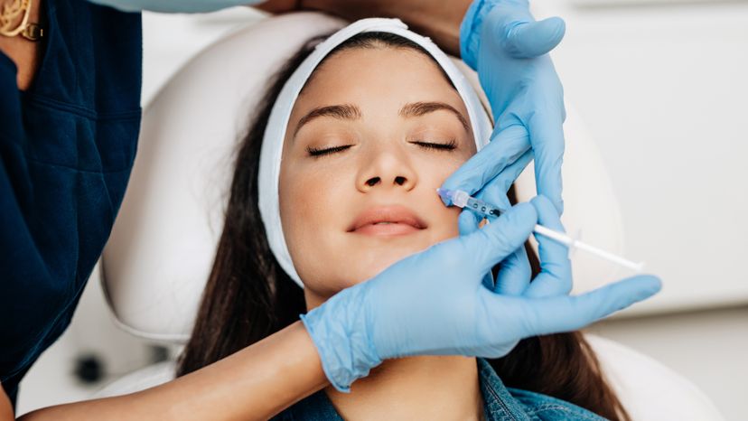 Attractive young woman is getting a rejuvenating facial injections at beauty clinic