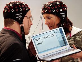 Two people in Germany use a brain-computer interface to write "how are you?"”border=