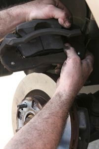 Person manually fixing the brake system in a vehicle.