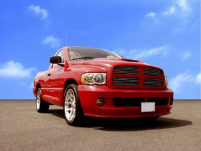 Large red pick-up truck parked in a barren setting.