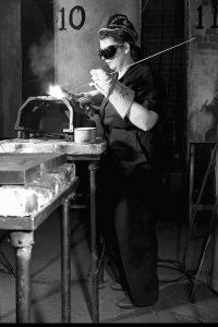 A woman brazing an automobile casting. 