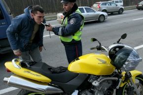 Police officer administering a roadside breathalyzer test to a driver.