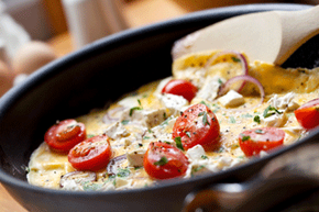 把鸡蛋搅拌成一个快速的、充满蔬菜的煎蛋卷是一种便宜又营养的家庭晚餐。查看更简单的工作日晚餐图片。＂width=