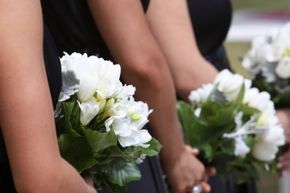 Bridesmaids hold bouquets.