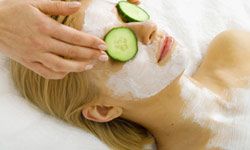 Woman with facial and cucumbers.